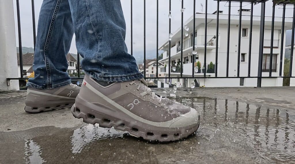 James McCormack wearing the On Cloudvista 2 waterproof shoe walking through rain and puddles, demonstrating Gore-Tex protection and trail-ready grip.