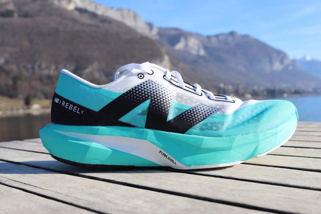 Picture of the New Balance Fuelcell Rebel v4 at annecy lake from the side in white and green