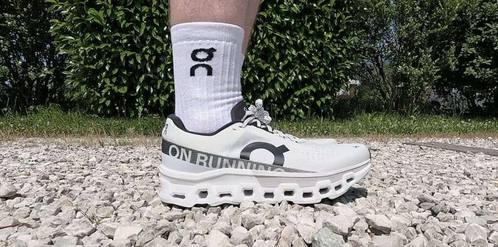 Photo from the side of the ON Cloudmonster 2 in white and black